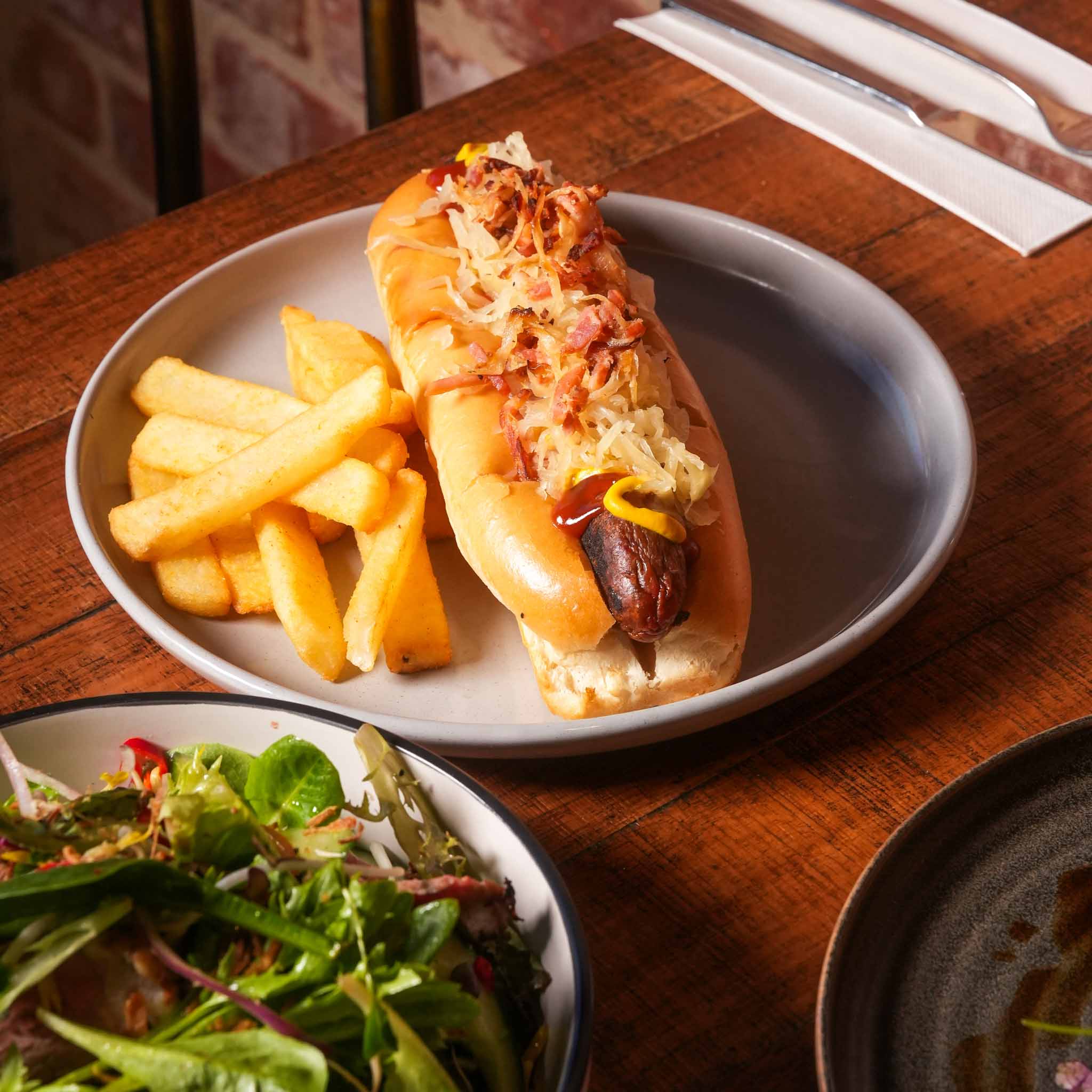 Bunnings' Finest Gourmet Sausage | Gourmet Sausage In A Toasted Brioche Bun With Sauerkraut, Bacon And Onion, Topped With Mustard And Tomato Sauce | $19.80